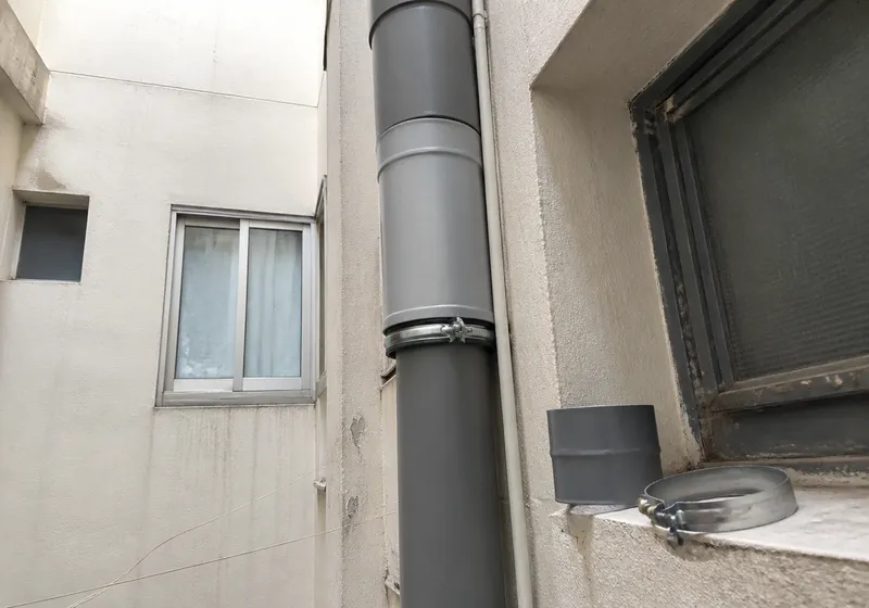 Tramo de bajante de PVC en un patio de luces durante una reparación de fontanería en Molina de Segura